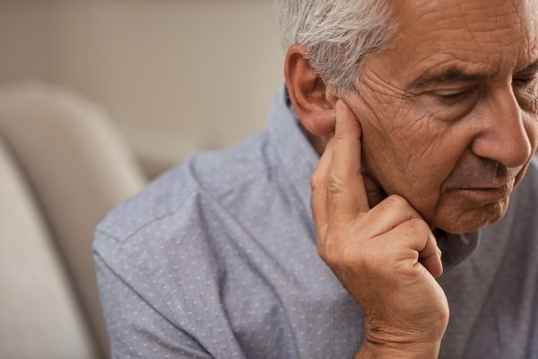 old man experiencing hearing loss