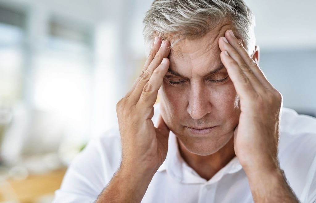 man holding-his head because of headache