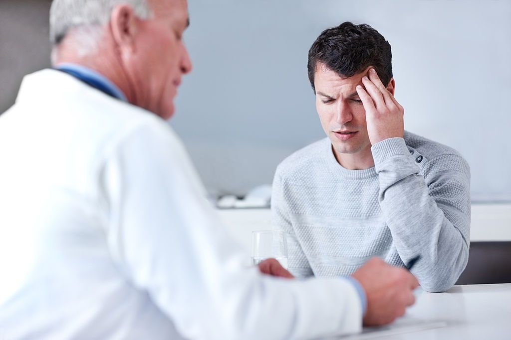 man reaching out to an ENT doctor for his migraine