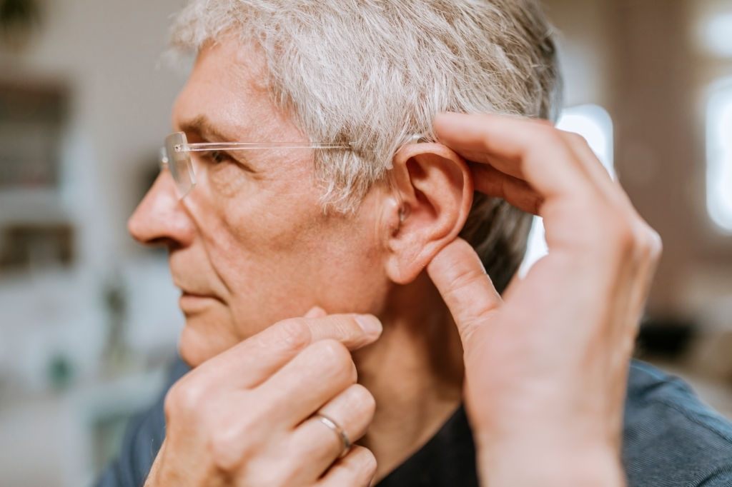 old man suffering from hearing loss